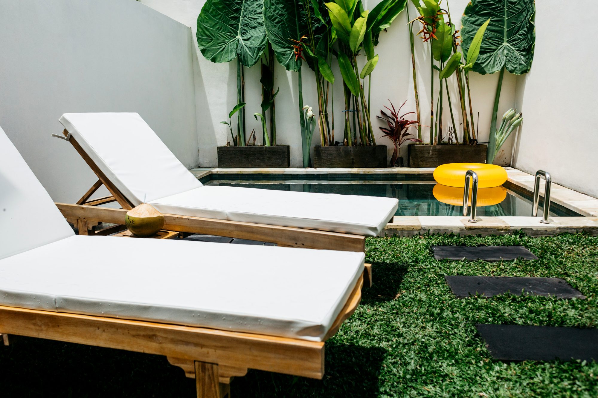 Sun loungers beside a private plunge pool and tropical garden — boutique villa, Ubud Bali